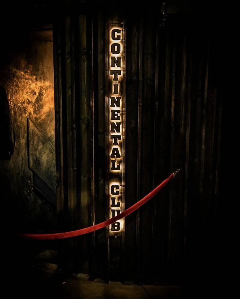 The lit Continental Club sign and a red rope at the entrance
