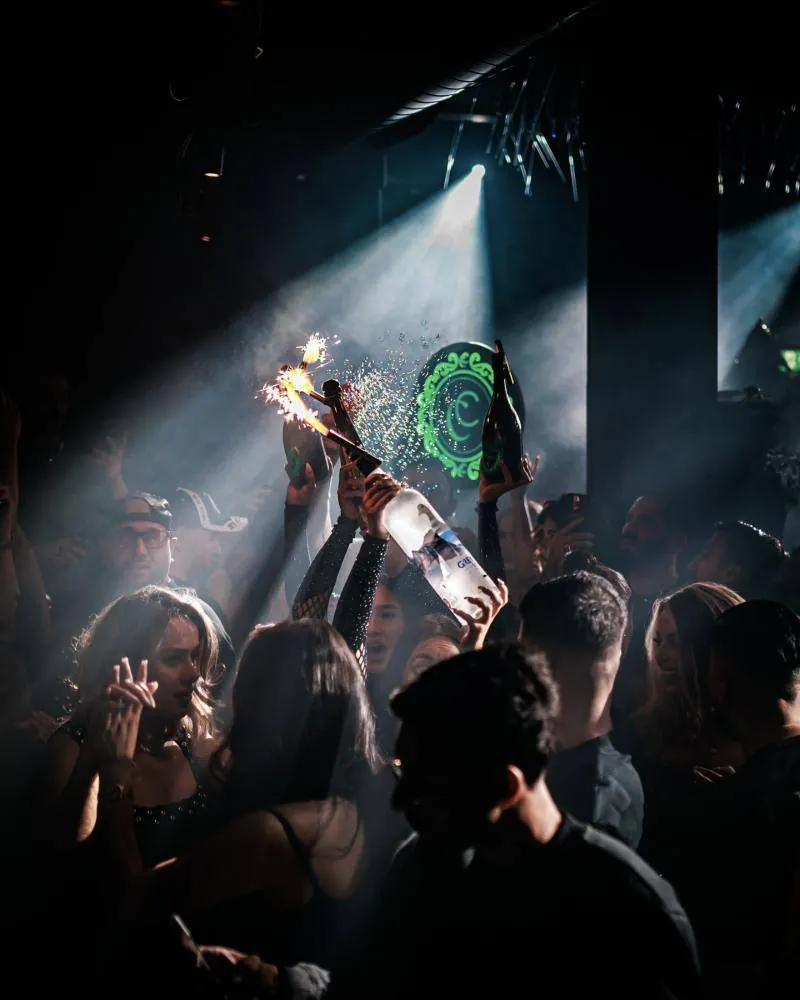Beams of light cutting through haze over the crowd