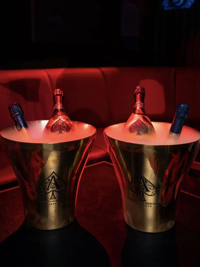Two champagne buckets on a red banquette table